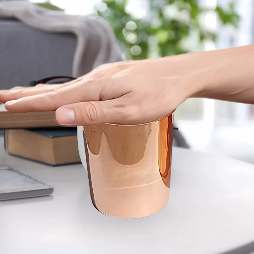 Mano sosteniendo un vaso de cobre