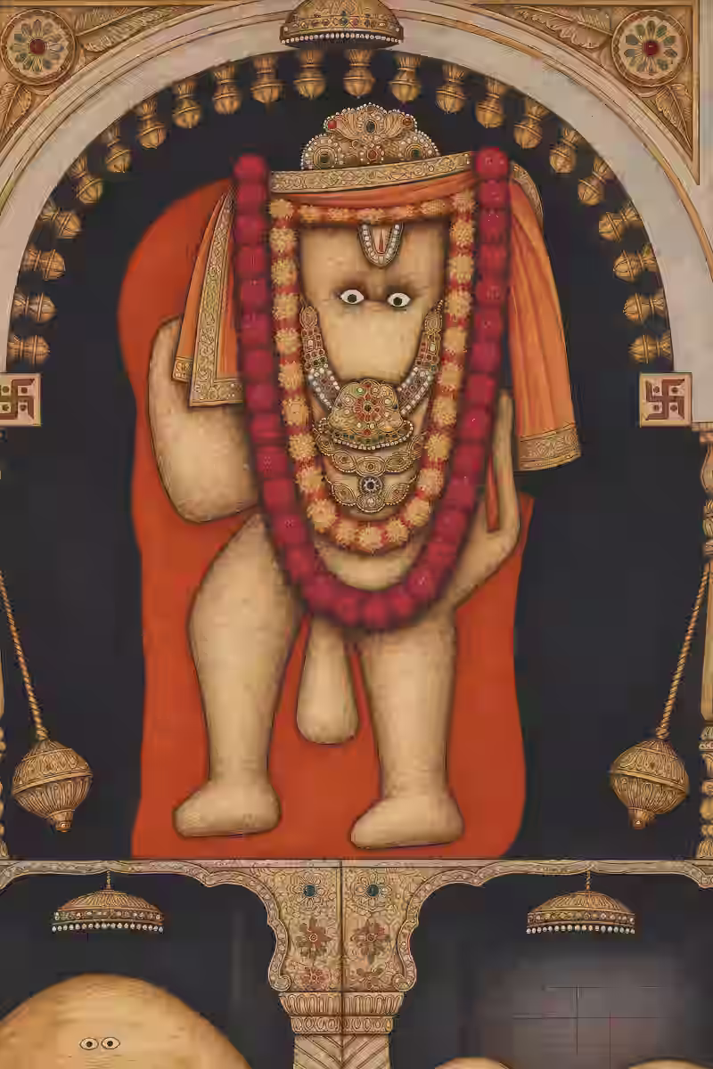 A highly revered, traditional temple deity depiction of Lord Hanuman adorned with heavy floral garlands and a golden crown.